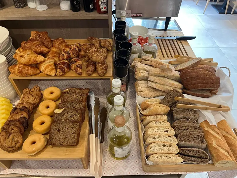 Une table garnie de viennoiseries, de pains et de condiments.