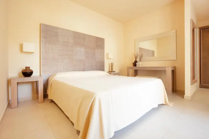 Une chambre lumineuse avec un grand lit recouvert de draps blancs.