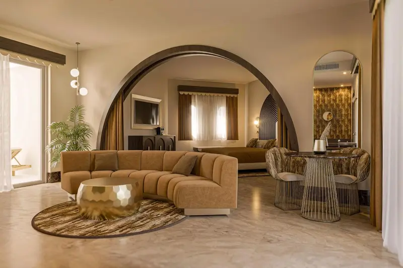 Un salon chaleureux avec canapé incurvé et table basse dorée.