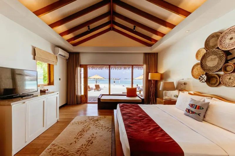 Une chambre lumineuse avec un grand lit et vue sur la mer.