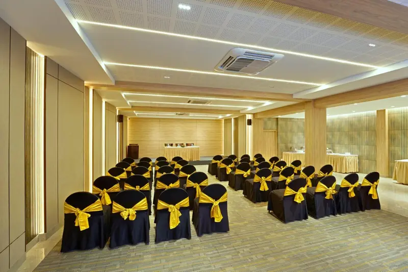 Une salle de réunion lumineuse avec des chaises alignées et des tables.
