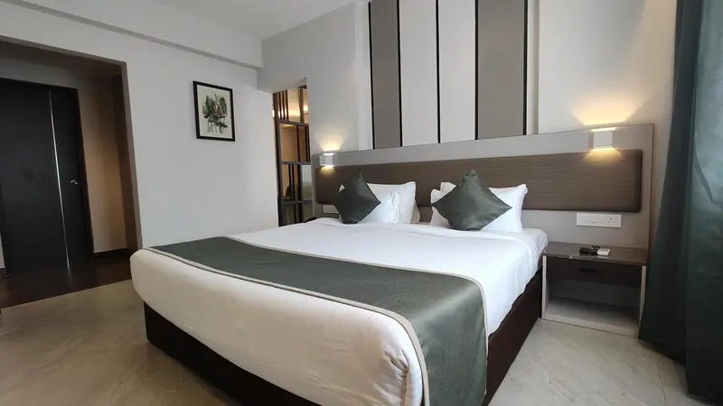 Une chambre lumineuse avec un grand lit et une décoration sobre.