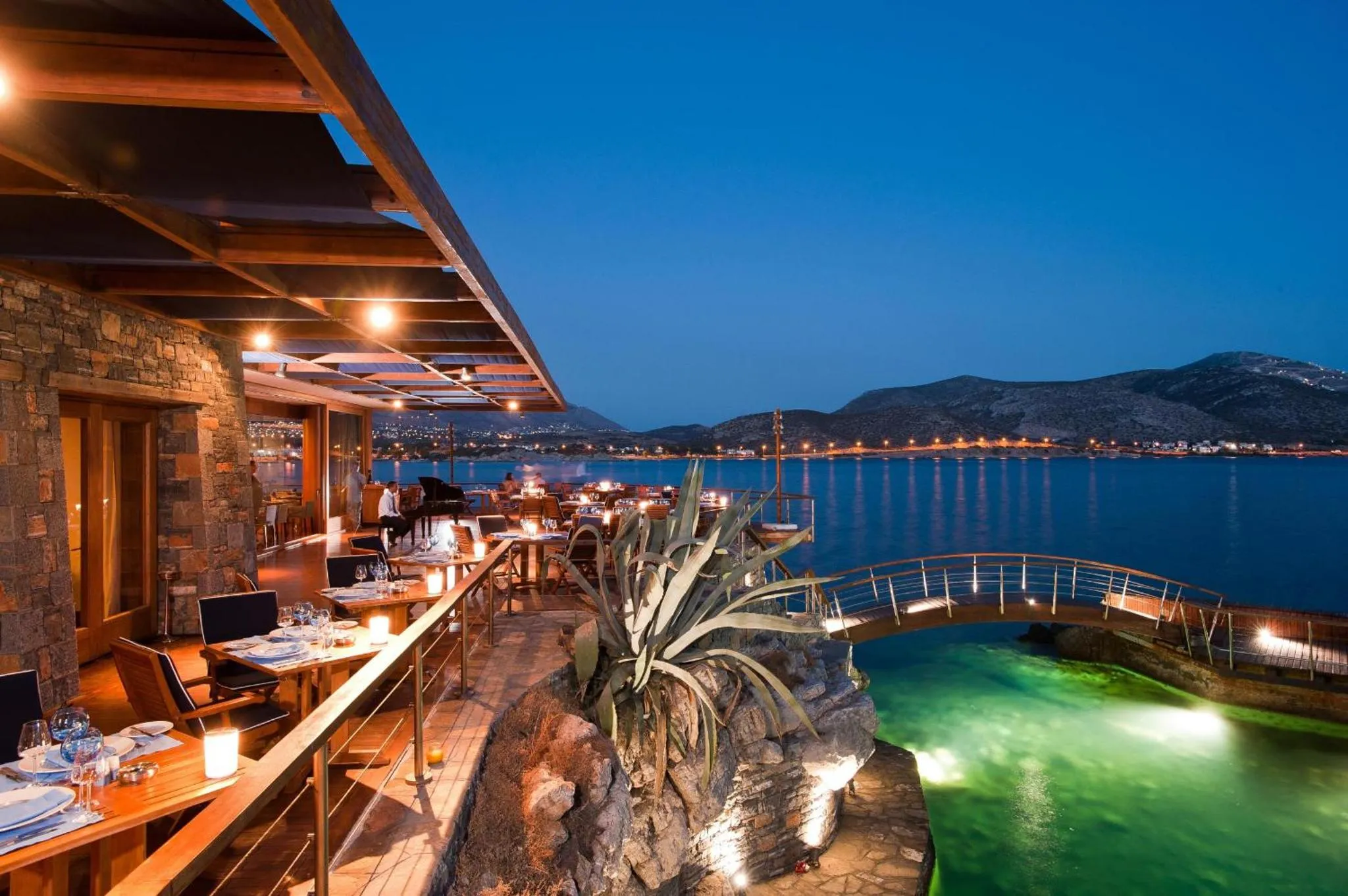 Terrasse de restaurant avec vue sur la mer au crépuscule.