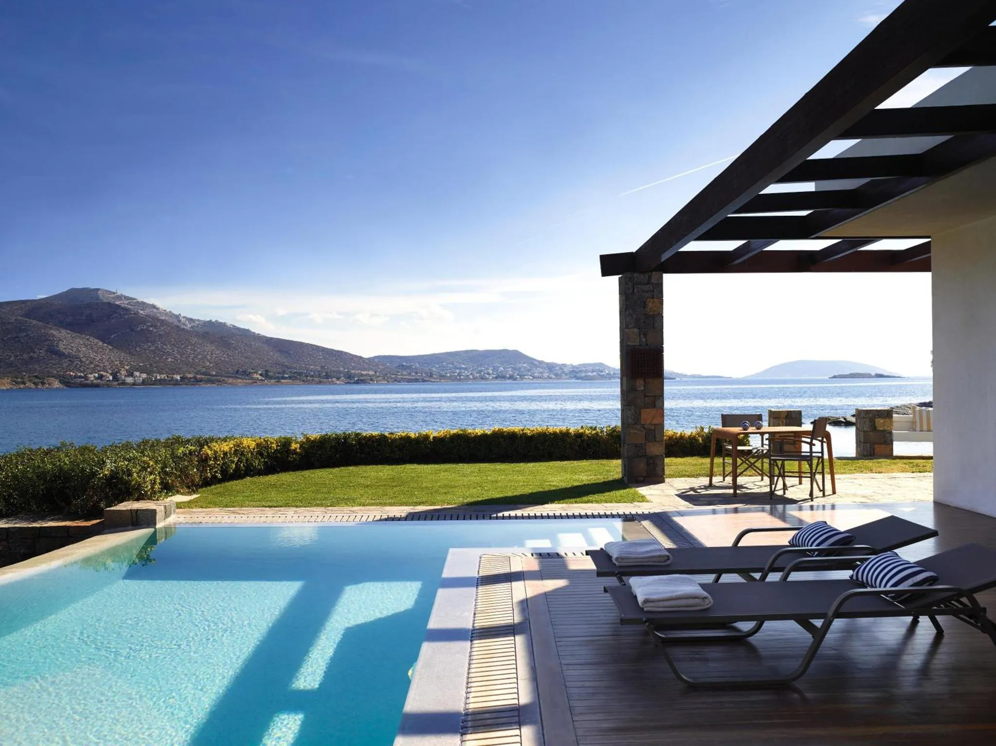 Terrasse avec piscine et vue sur la mer et les montagnes.