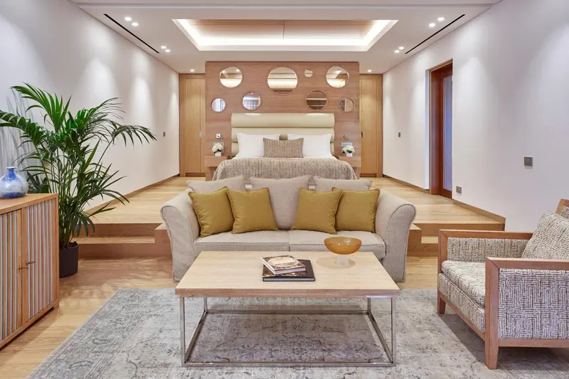 Espace de vie intérieur avec canapé, table basse et lit surélevé.