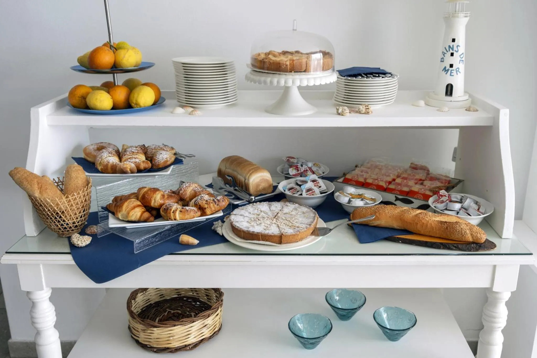 Un buffet propose des pâtisseries, des fruits et des viennoiseries.