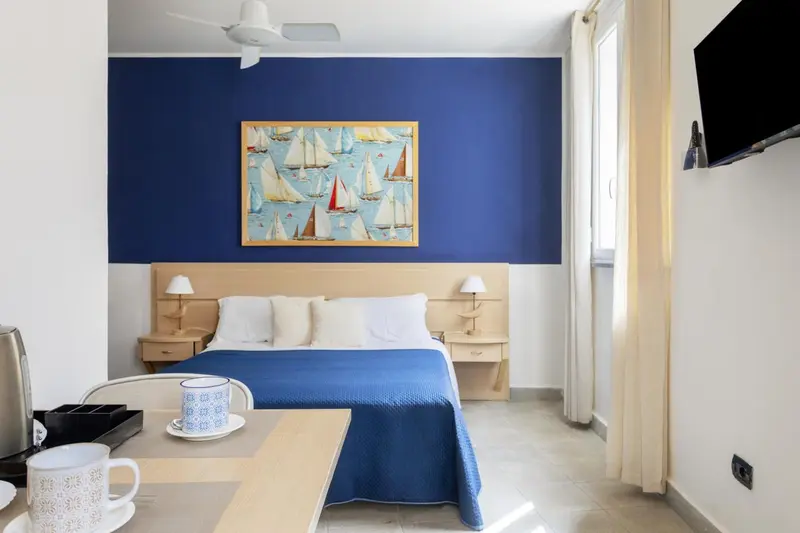 Une chambre lumineuse avec un lit double et une décoration maritime.