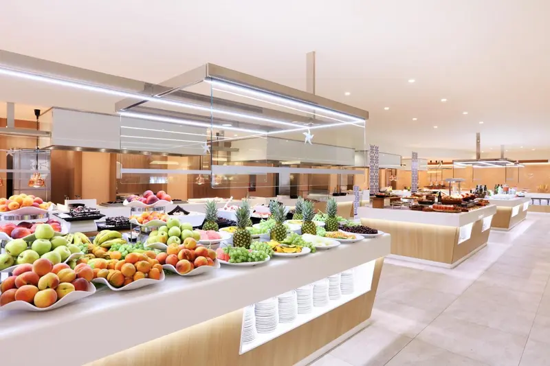 Un buffet propose une grande variété de fruits frais et de pâtisseries.