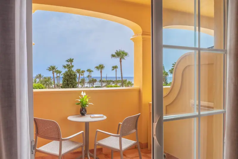 Vue sur la mer depuis une terrasse avec mobilier de jardin.