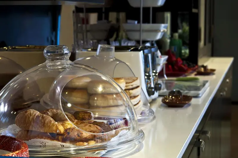 Présentation de pâtisseries sur un buffet blanc.