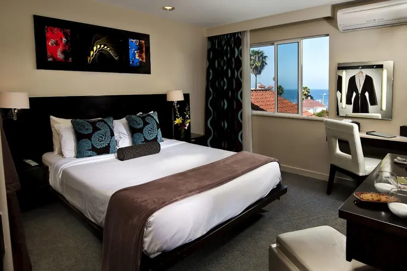 Une chambre avec un grand lit et une vue sur la mer par la fenêtre.