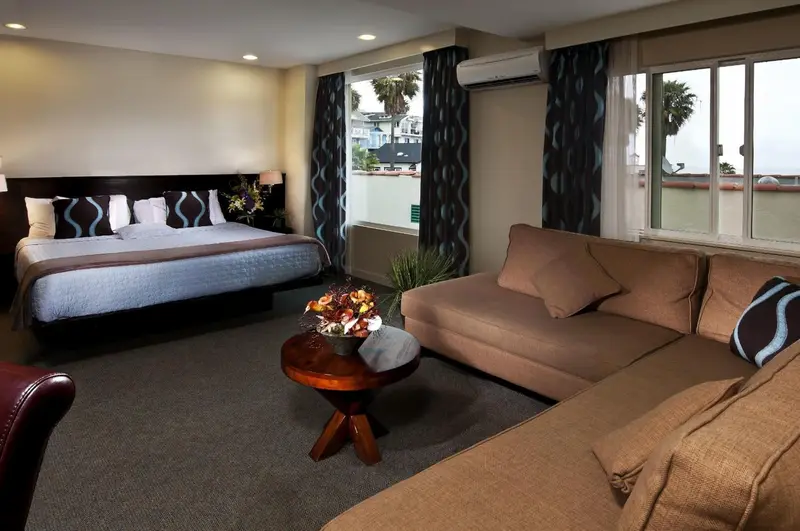 Une chambre lumineuse avec un grand lit et un coin salon confortable.