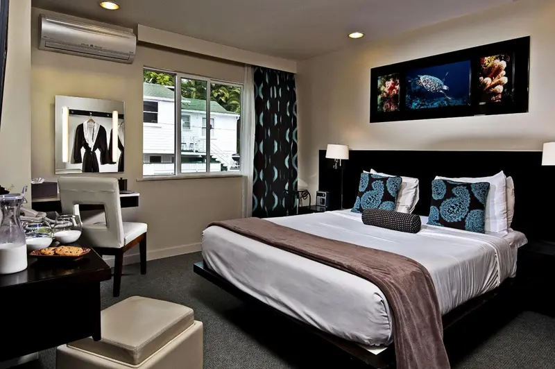 Une chambre moderne avec un grand lit et un téléviseur mural.