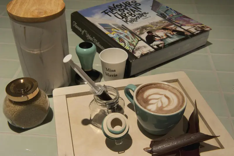 Une tasse de café et des accessoires sur un plateau.