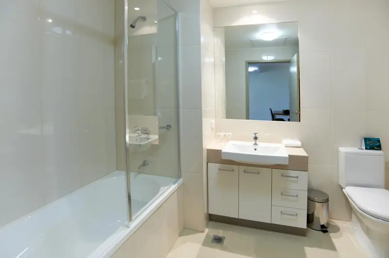 Une salle de bain claire avec baignoire et lavabo.