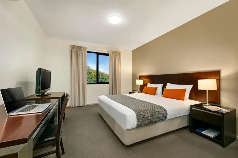 Une chambre d'hôtel lumineuse avec un lit double et un espace de travail.