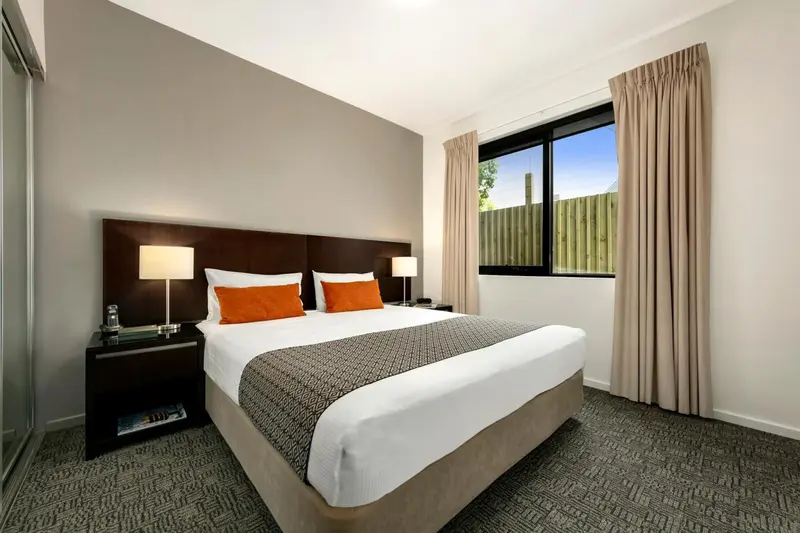 Une chambre avec un grand lit recouvert d'une couette et de coussins.