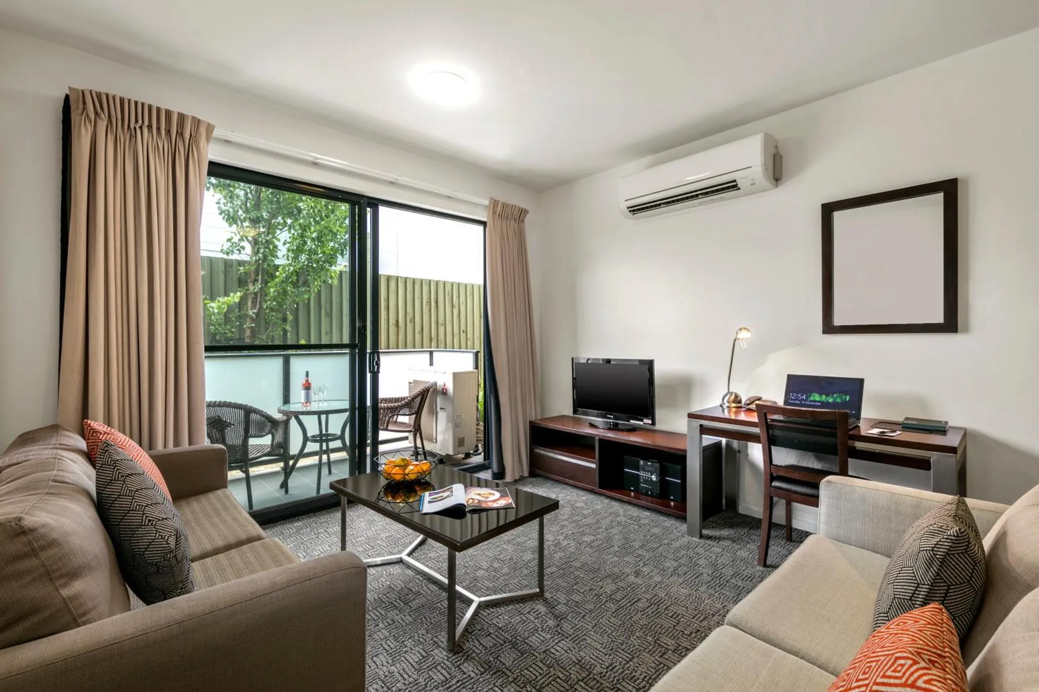 Espace de vie intérieur avec canapés, table basse et accès à une terrasse.