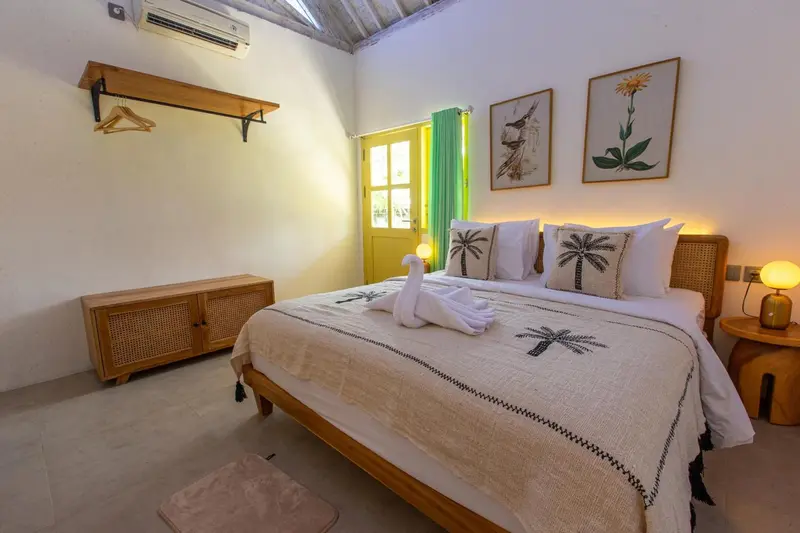 Une chambre lumineuse avec un lit décoré de serviettes en forme de cygnes.
