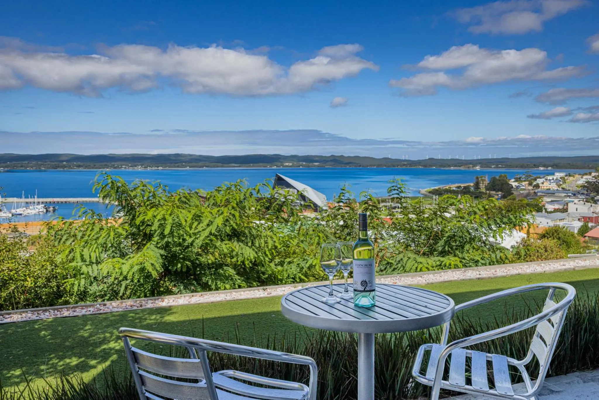 Une table et deux chaises offrent une vue sur la mer et la ville.