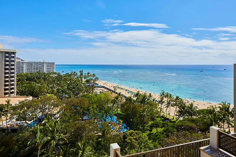 Vue panoramique sur la mer, une plage et la végétation luxuriante.