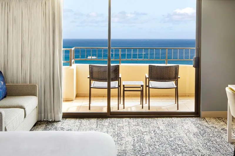 Vue sur la mer depuis une terrasse avec mobilier de jardin.