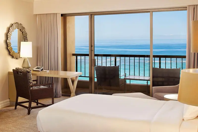 Une chambre avec vue sur la mer depuis un balcon.
