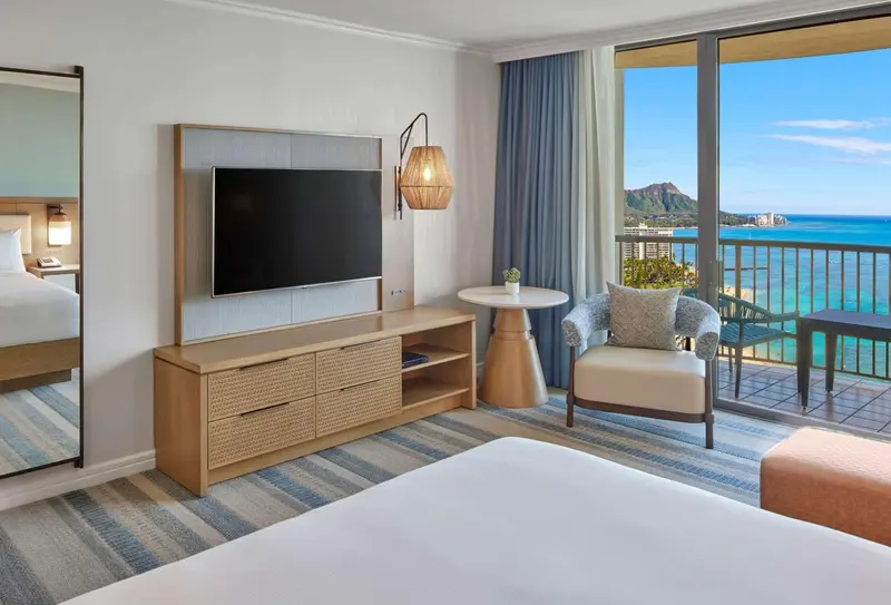 Chambre lumineuse avec vue sur la mer et un coin salon.