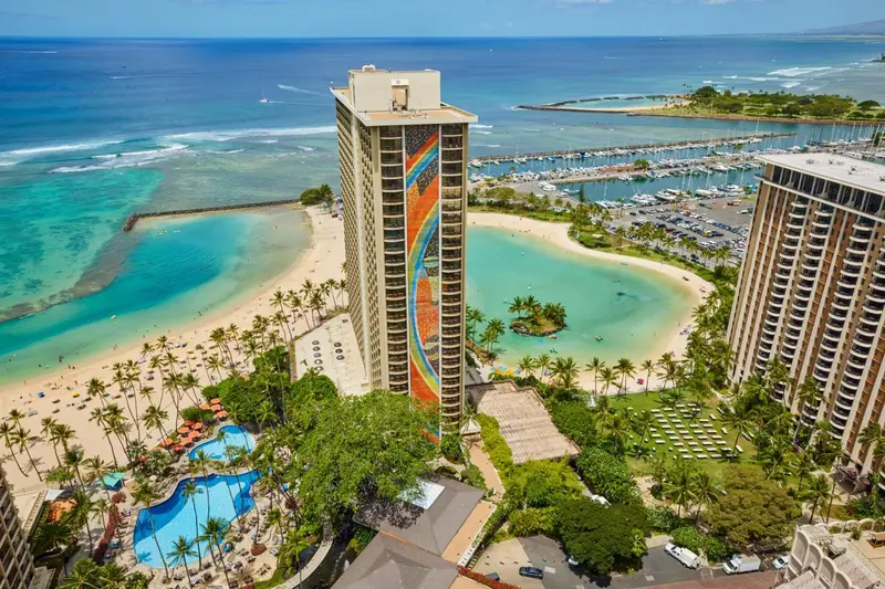 Vue aérienne d'un complexe hôtelier bordant une plage et un lagon.