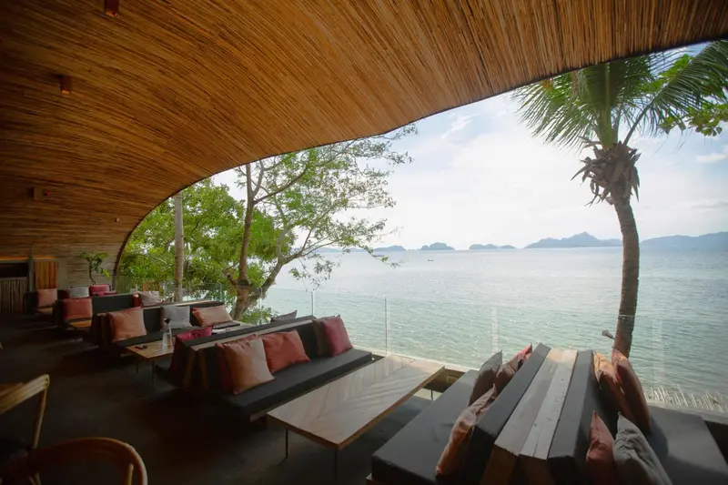 Espace de détente avec canapés et vue sur la mer.