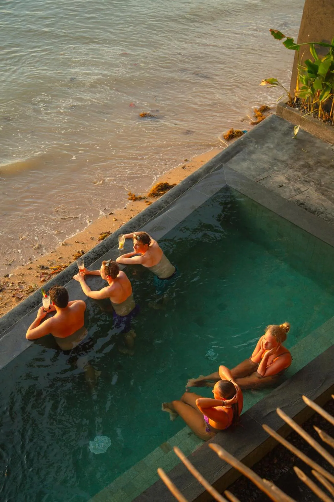 Des personnes se détendent au bord d'une piscine à débordement avec vue sur la mer.