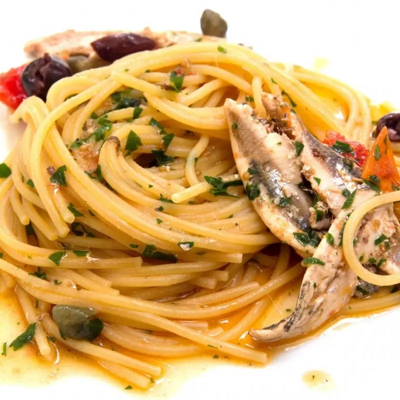 Assiette de spaghetti aux anchois, câpres et olives.