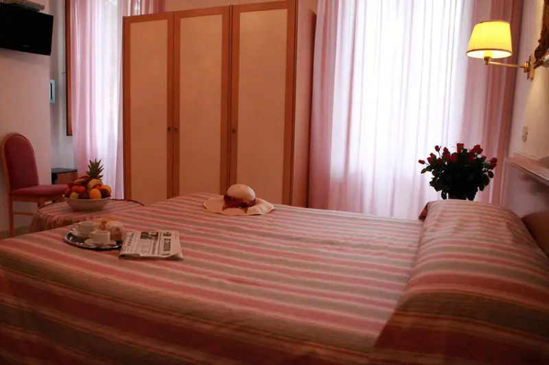 Une chambre d'hôtel avec un lit fait et une table de chevet.