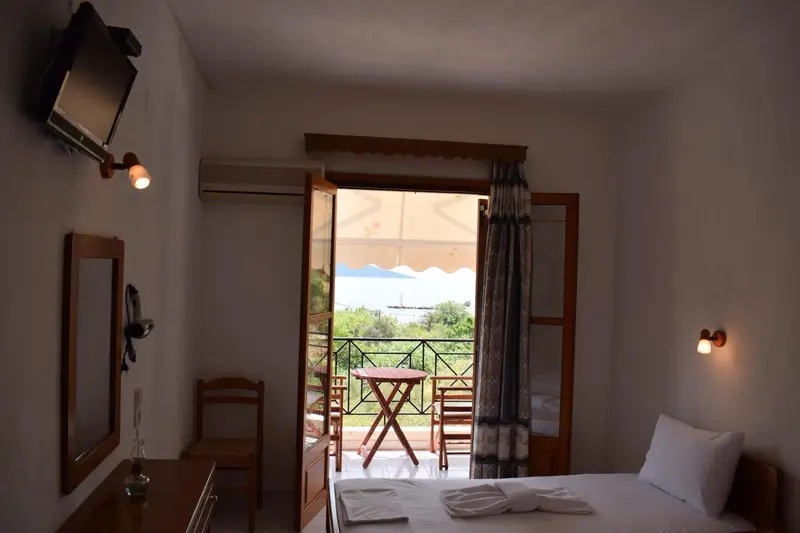 Une chambre lumineuse s'ouvre sur une terrasse avec vue sur la mer.