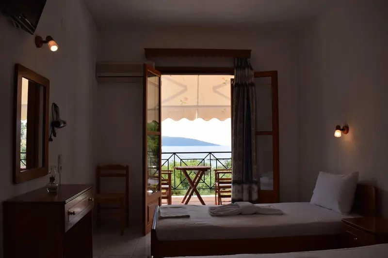 Une chambre lumineuse s'ouvre sur une terrasse avec vue sur la mer.