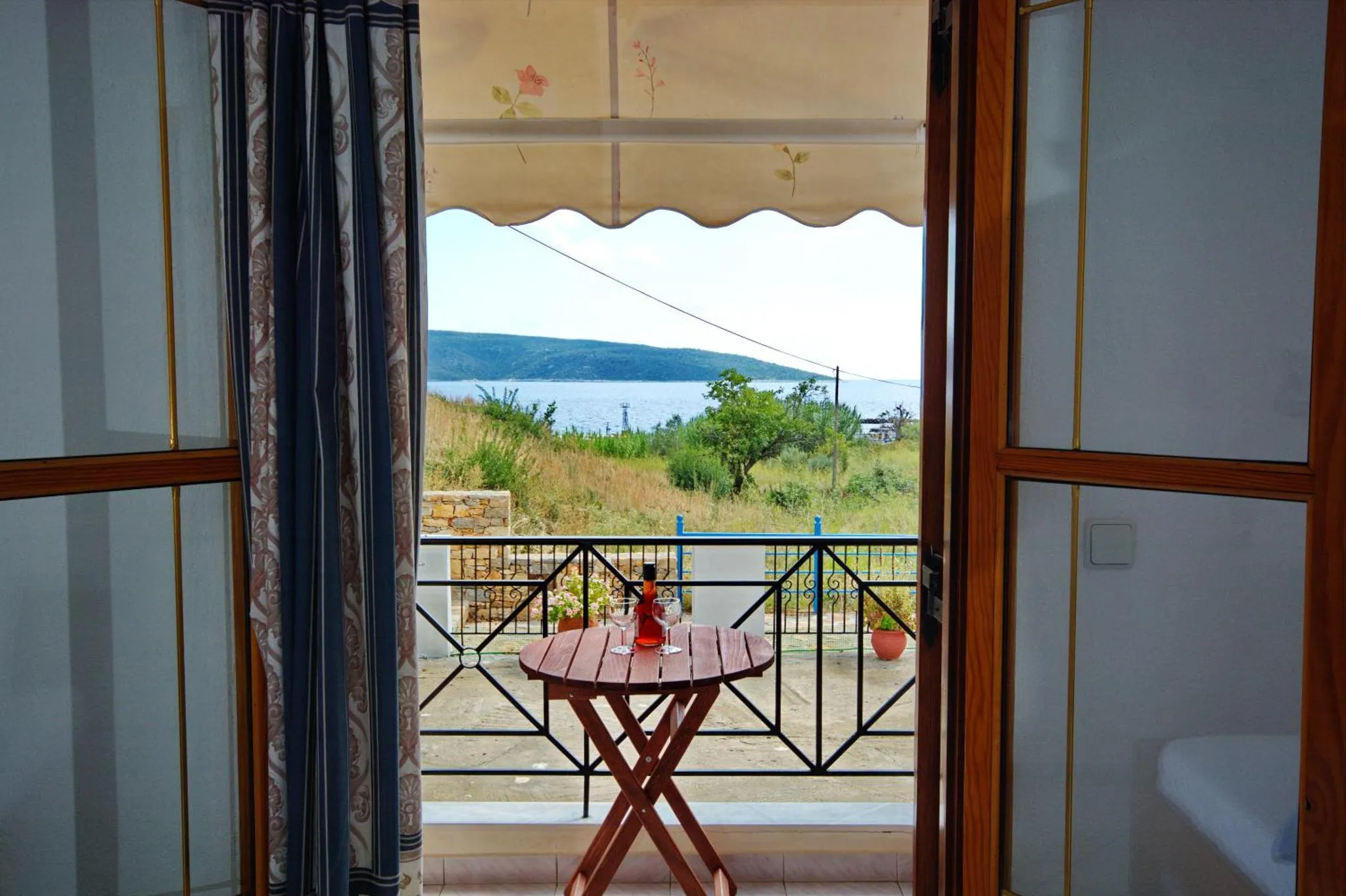 Vue sur la mer depuis une terrasse ombragée.