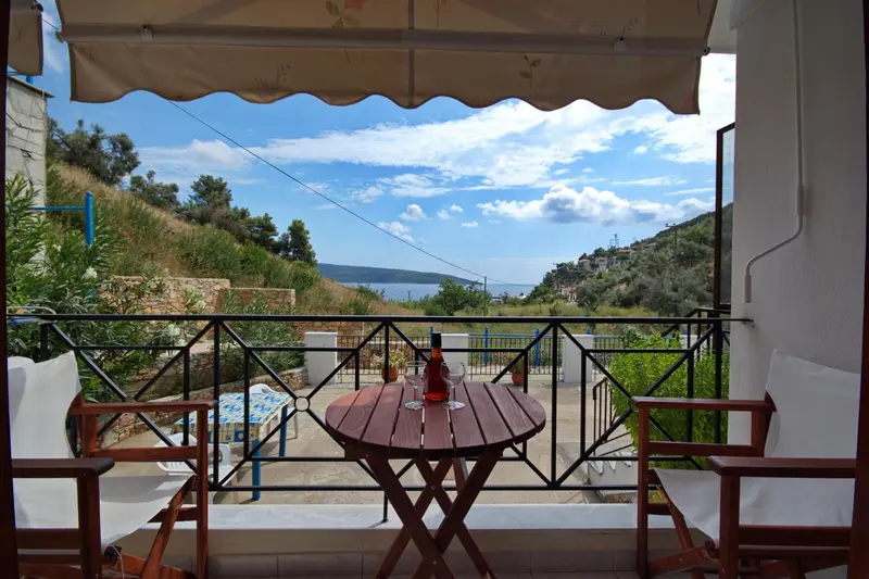 Une terrasse ombragée donne sur une vue dégagée sur la mer et les collines.