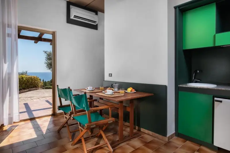 Une table est mise avec des couverts et des fruits dans une pièce lumineuse.