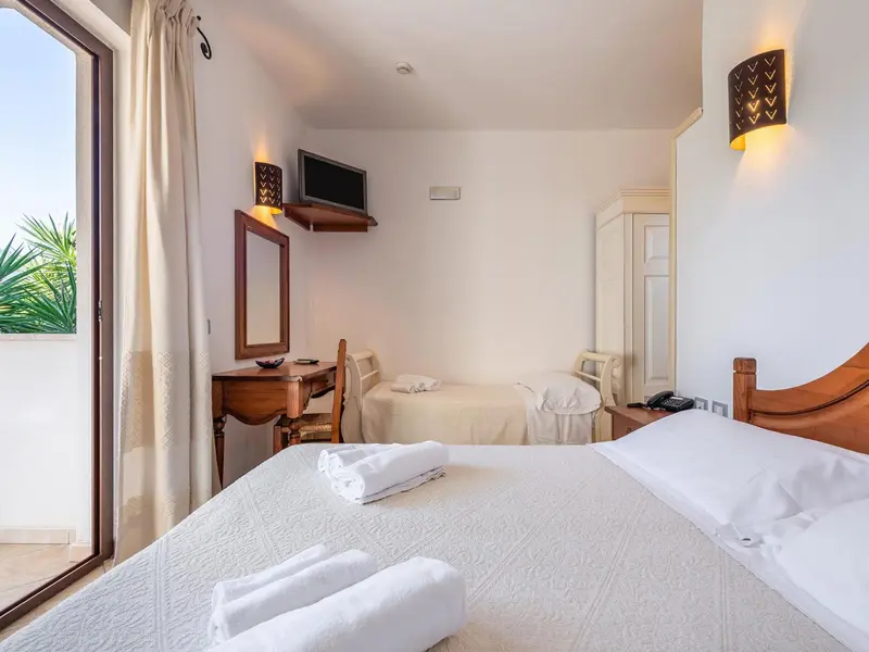 Une chambre lumineuse avec un lit double et un bureau.