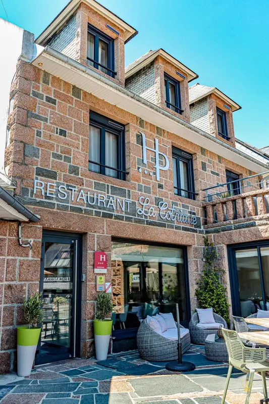 Façade d'un bâtiment en pierre avec un restaurant et une terrasse.