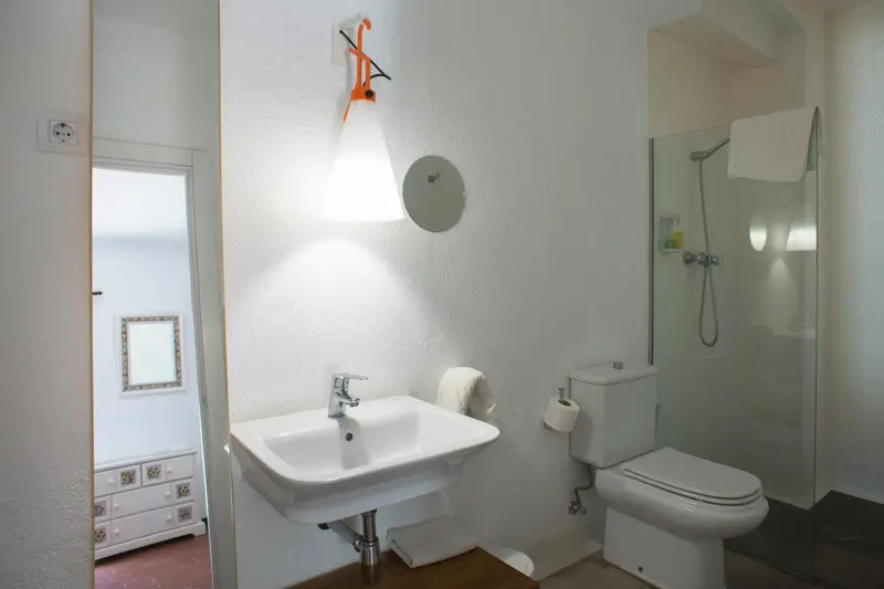 Une salle de bain claire avec douche et lavabo.