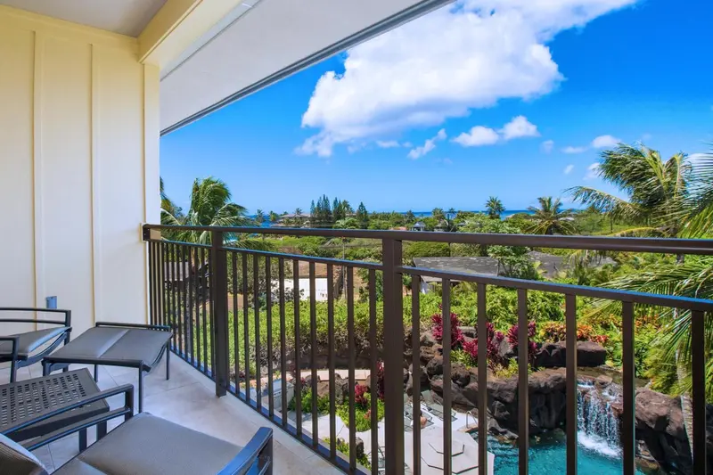 Terrasse avec mobilier d'extérieur donnant sur un paysage tropical.