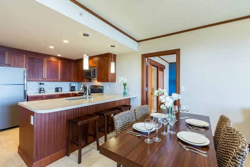 Une cuisine ouverte sur un espace repas avec un îlot central et une table à manger.