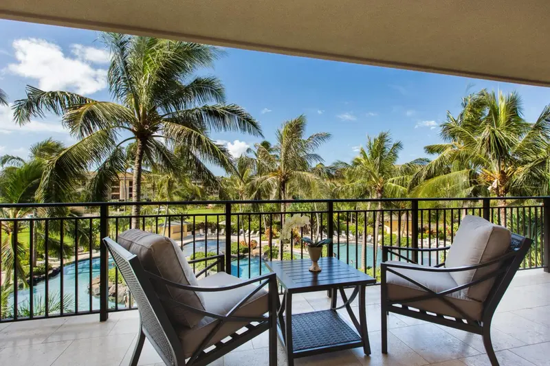 Terrasse aménagée avec mobilier de jardin donnant sur une végétation luxuriante et une piscine.