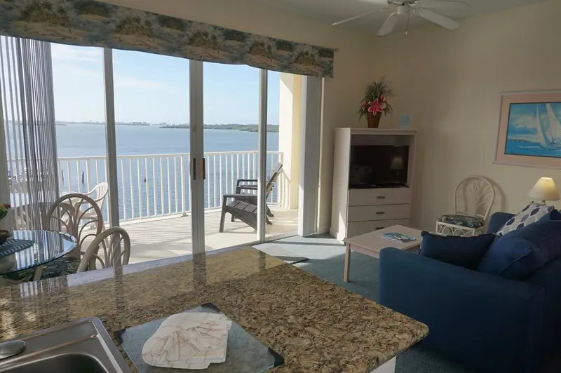 Espace de vie lumineux avec vue sur la mer depuis un balcon.