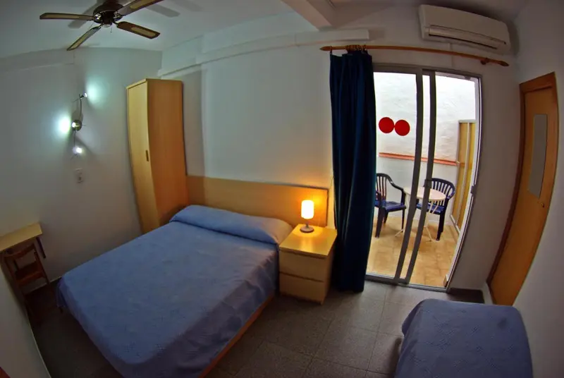 Une chambre avec un lit et un accès à une terrasse.
