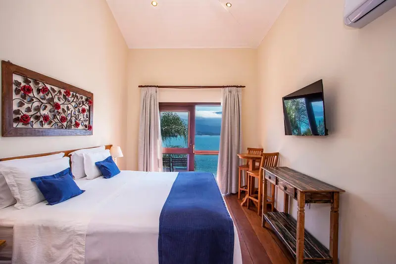 Une chambre lumineuse avec un grand lit et une vue sur la mer.