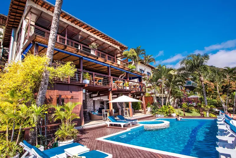 Bâtiment à plusieurs niveaux avec terrasses et piscine ensoleillée.