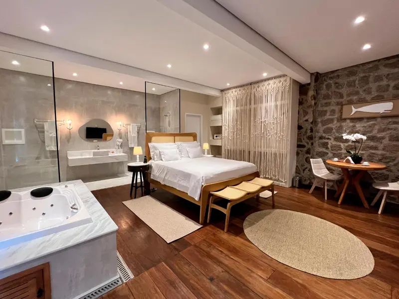 Chambre spacieuse avec lit king-size, baignoire et coin repas.
