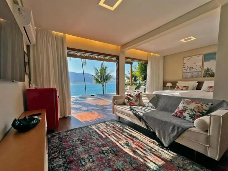 Une chambre lumineuse s'ouvre sur une terrasse avec vue sur la mer.